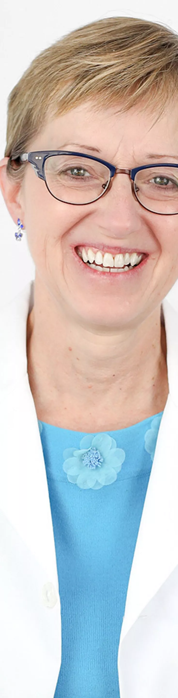 Headshot of Joie Flees.  She is wearing a white coat and a blue blouse.