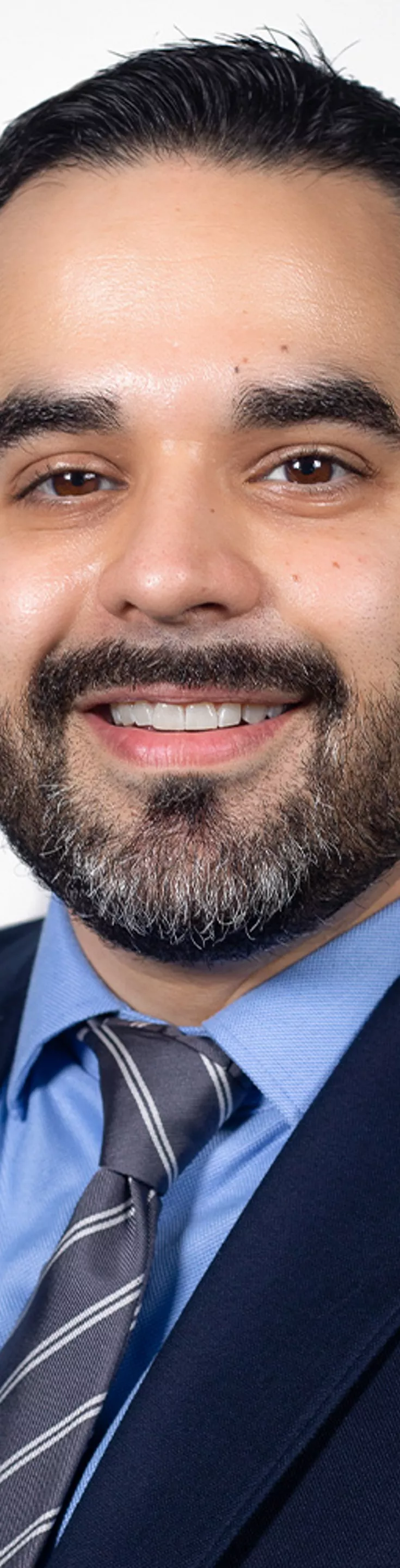 Headshot of Greg Fonzo. He is wearing a dress shirt, blue tie, and dark blue suit.