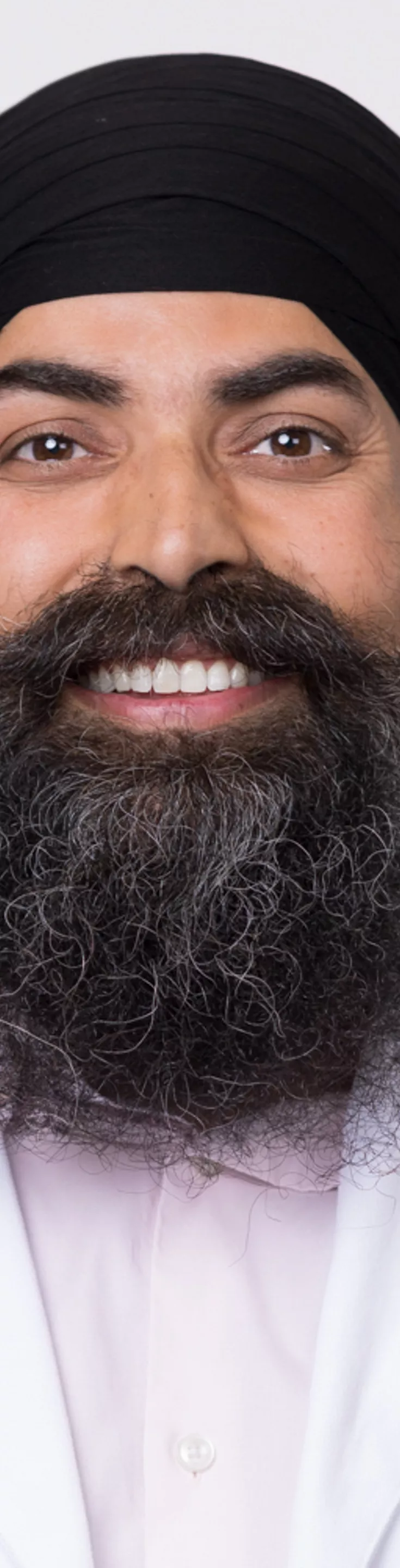 Headshot of Gurpreet Singh. He is wearing a pink dress shirt and a white coat.