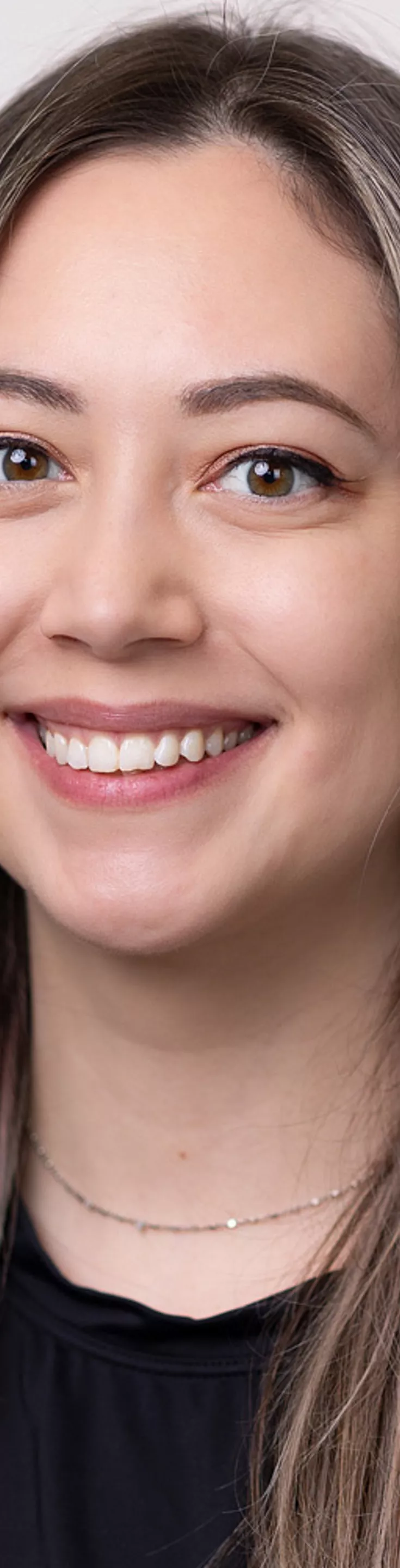 Headshot of Hannah Powers. She is wearing a black blouse and a green sweater.