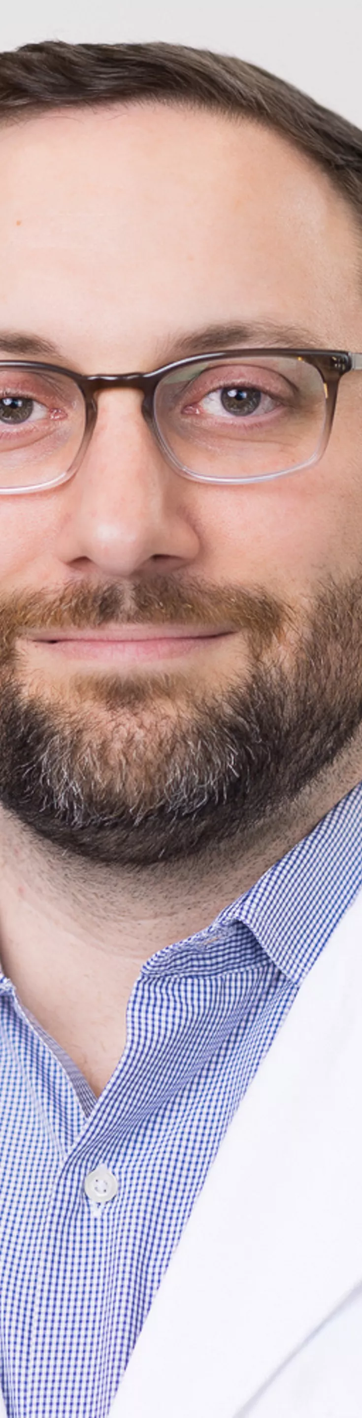 Headshot of Jared Fridley. He is wearing a blue dress shirt and a white coat.