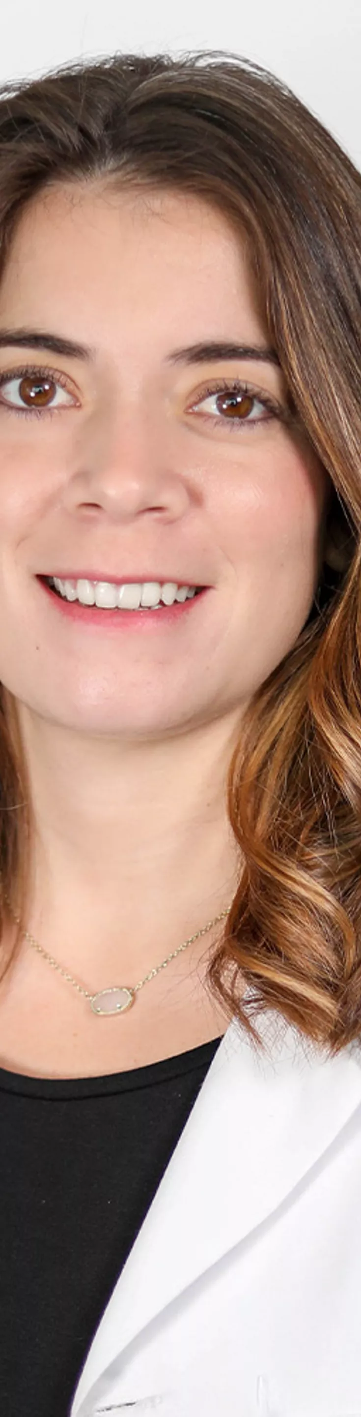 Headshot of Joanna Lopez. She is wearing a black blouse and a white coat.