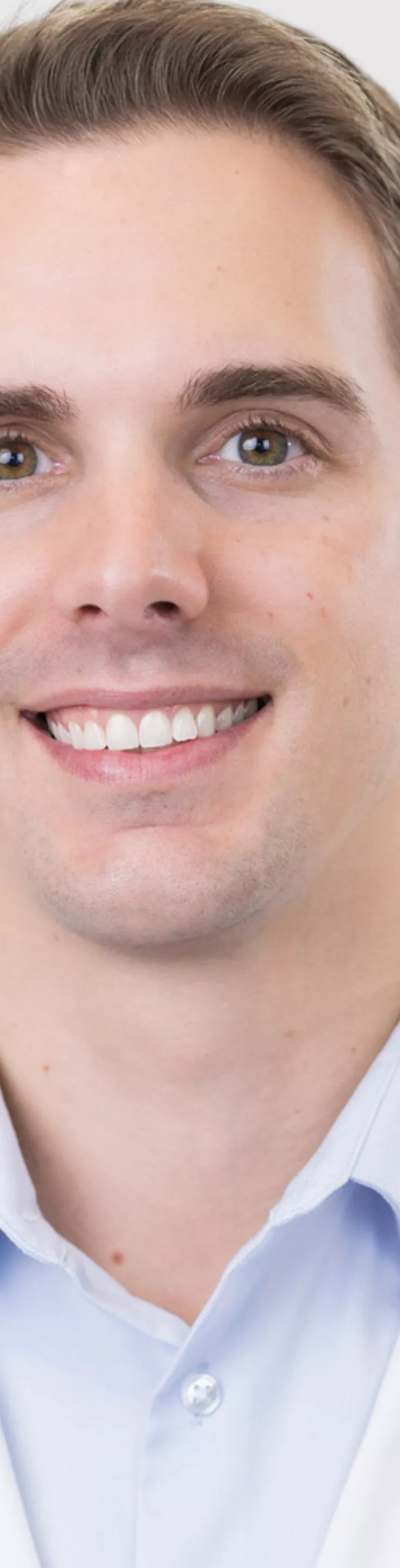Headshot of Jonathan Mason. He is wearing a blue dress shirt and a white coat.