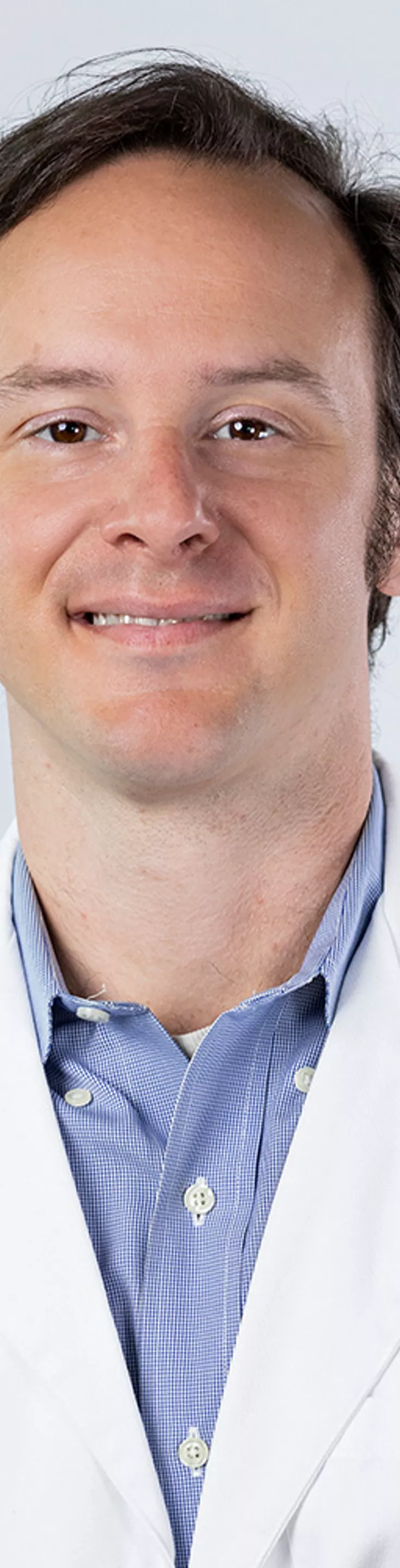 Headshot of Josh Cisler. He is wearing a blue dress shirt and a white coat.