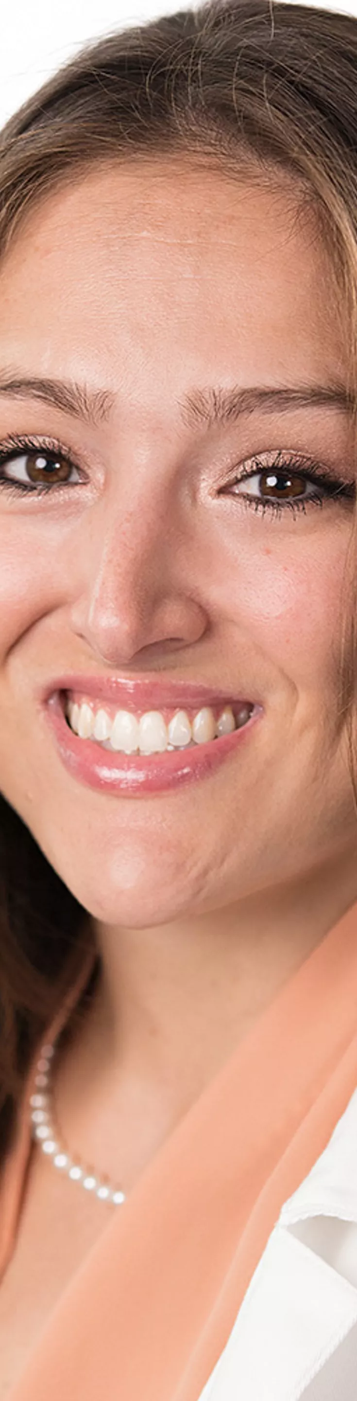 Headshot of Justin Reilly. She is wearing an orange blouse and a white coat.