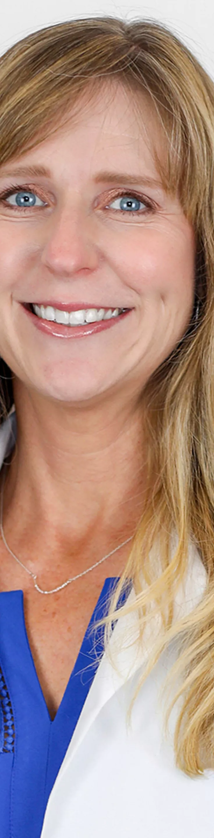 Headshot of Kristin Vinueza.  She is wearing a white coat and a blue blouse.