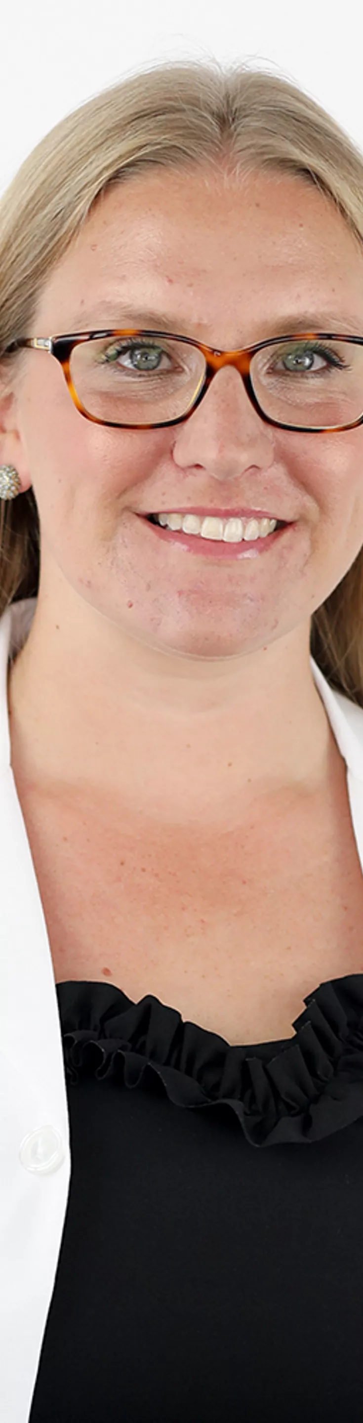 Headshot of Margaret Whitney. She is wearing a black blouse and a white coat.