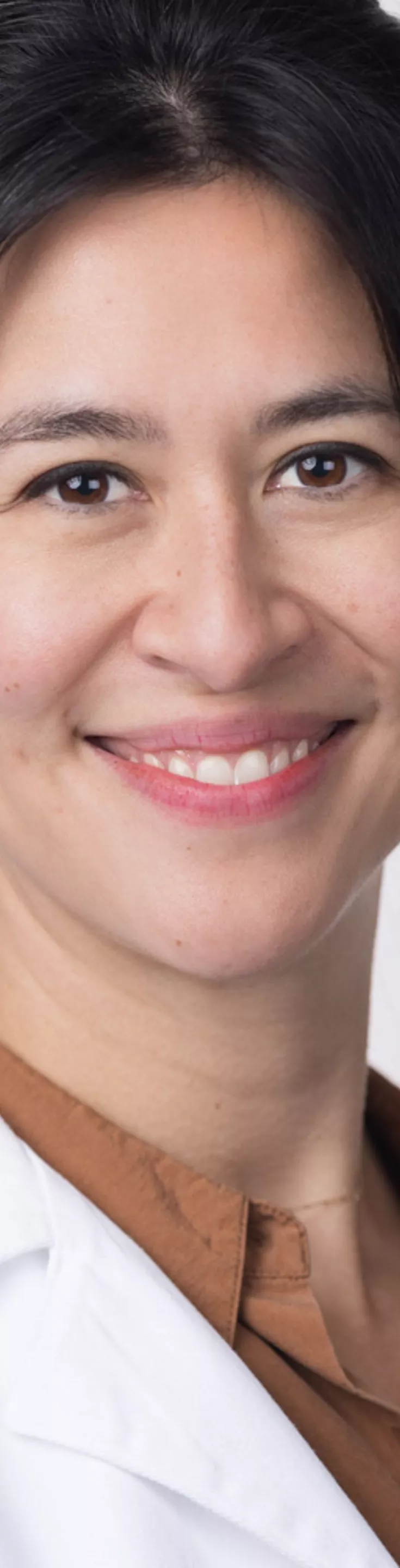 Headshot of Meagan Willaims. She is wearing a brown blouse and a white coat.