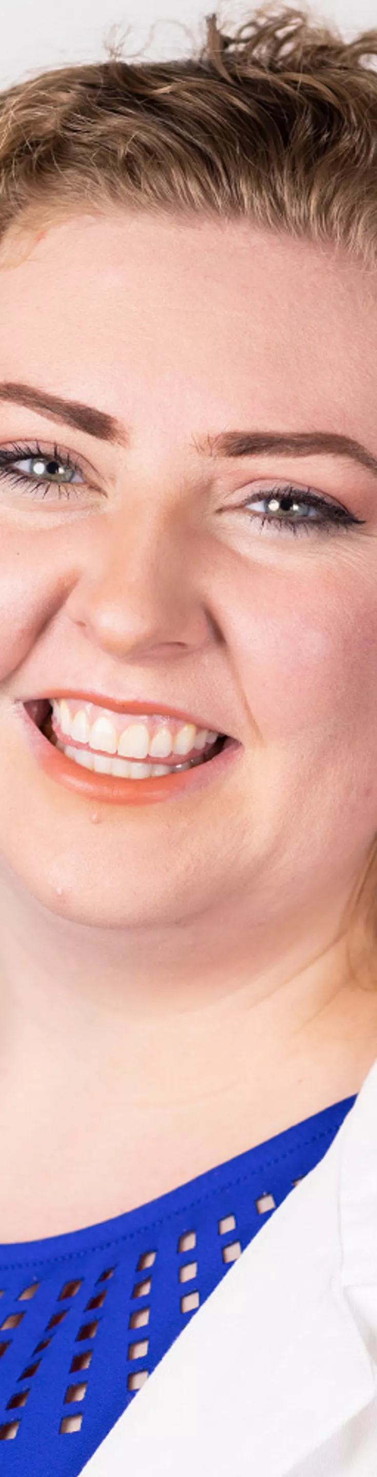 Headshot of Sarah Poole. She is wearing a blue blouse and a white coat.