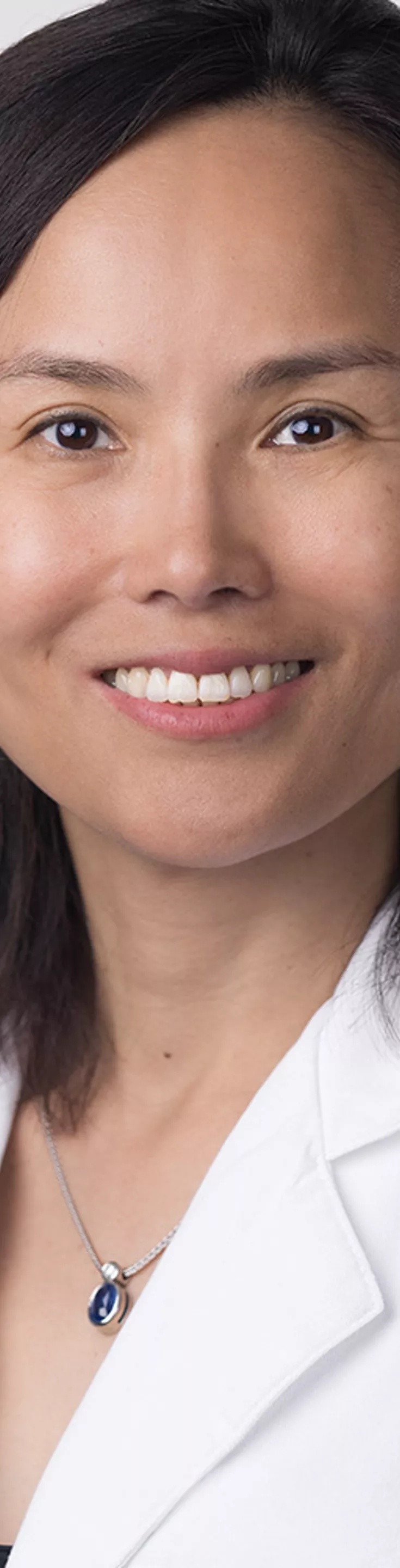 Headshot of Suyuan Li. She is wearing a black blouse and a white coat.