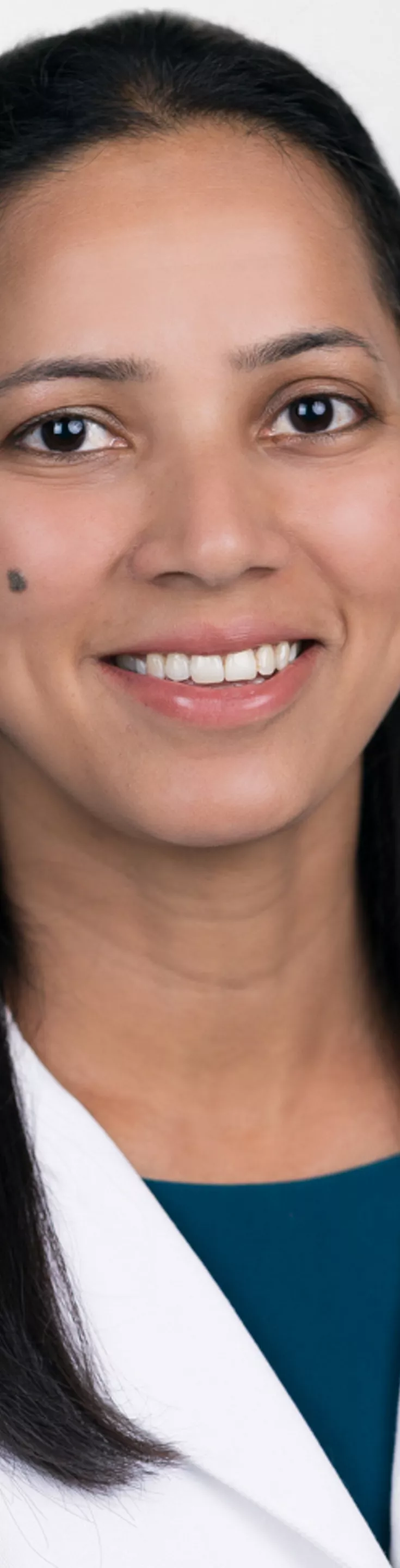Headshot of Sowmya Boddhula. She is wearing a blue blouse and a white coat.