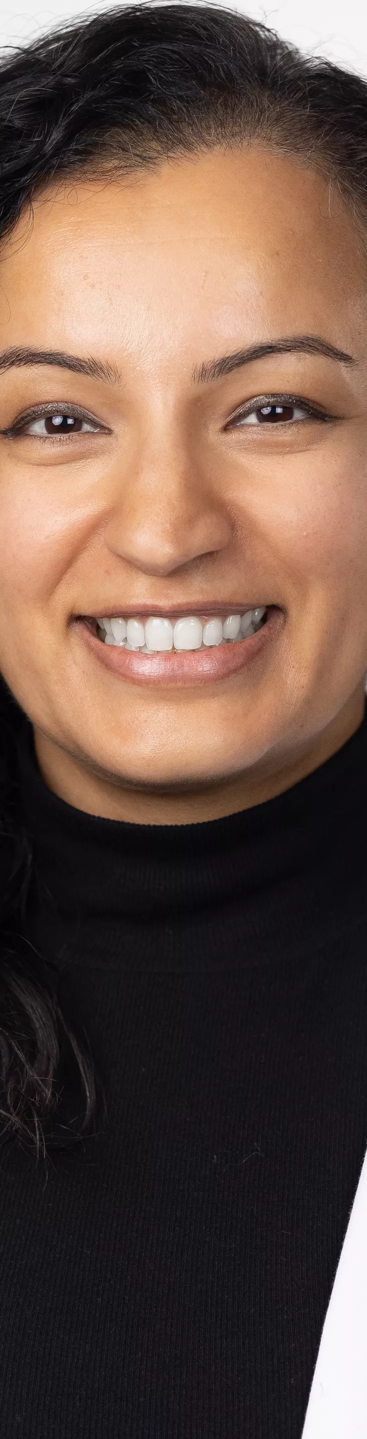 Headshot of Trisha Parekh. She is wearing a black blouse and a white coat.