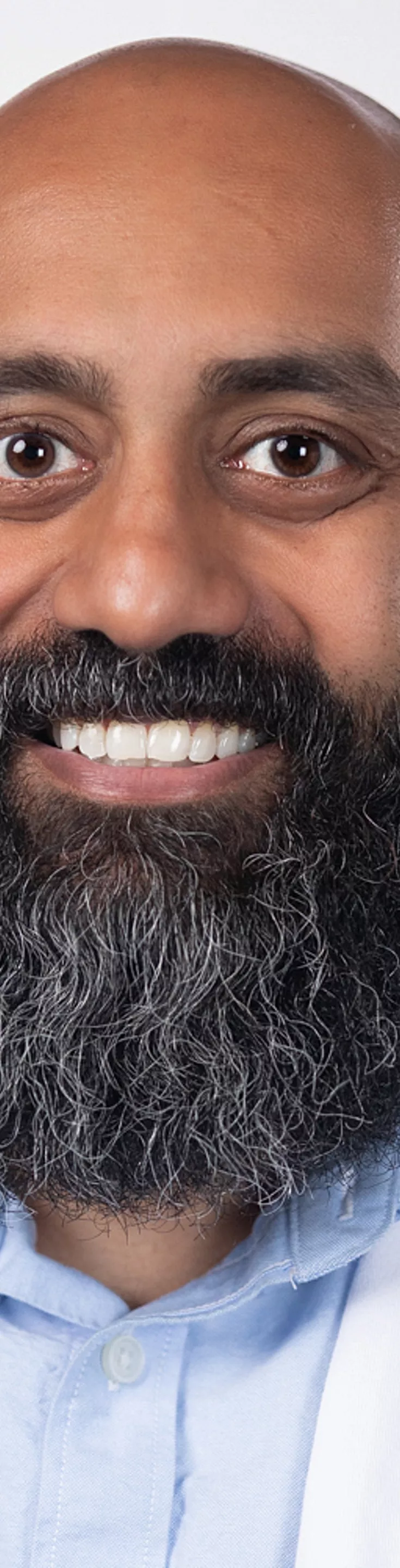 Headshot of Vijay Gorrepati. He is wearing a light blue dress shirt and a white coat.
