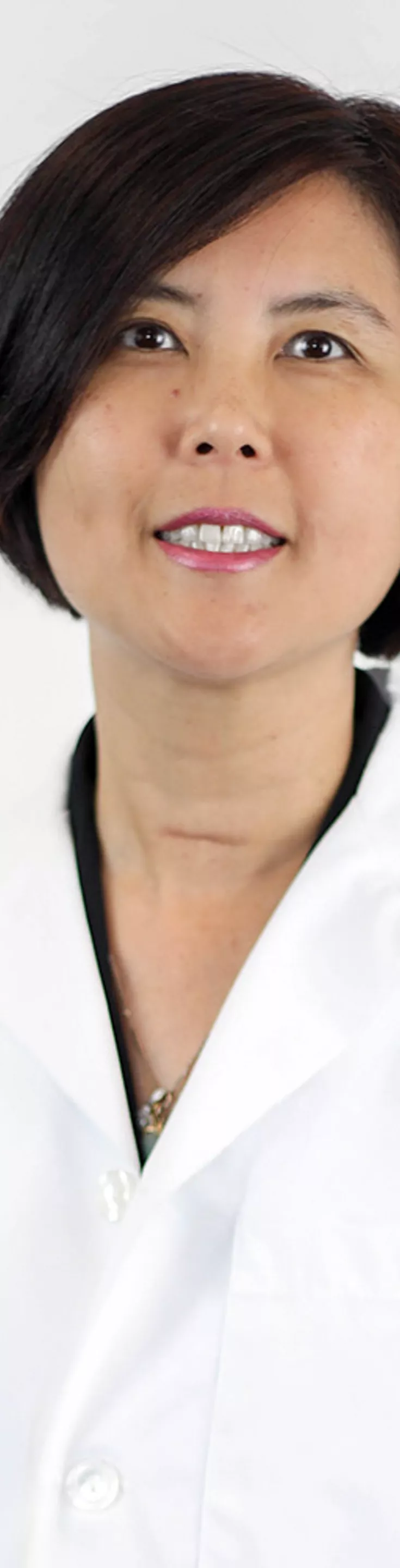 Headshot of Winifred Mak.  She is wearing a white coat and a black blouse.