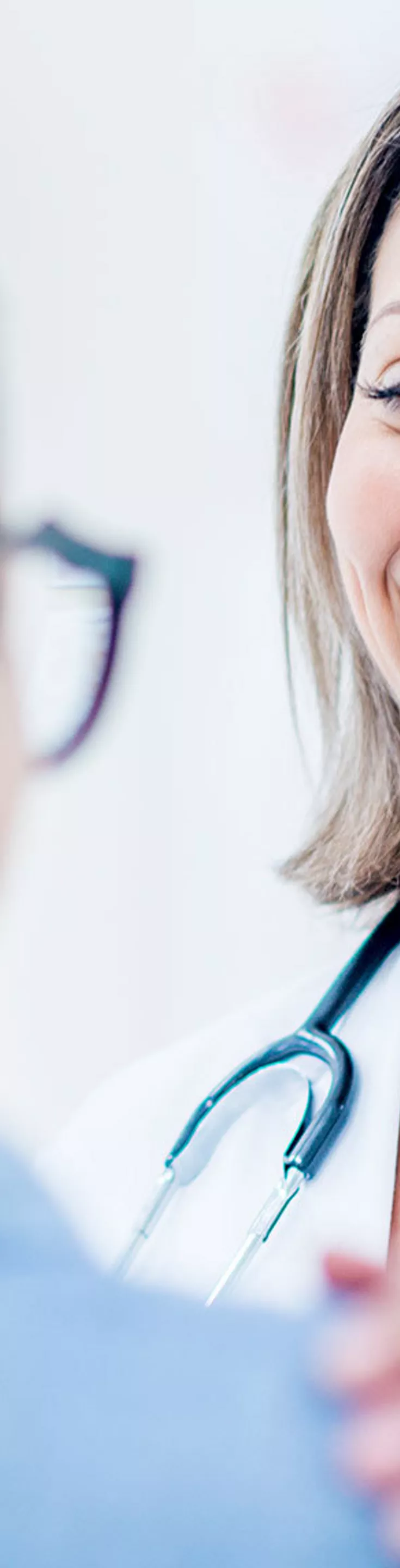 A healthcare professional wearing a white coat and stethoscope gently reassures a patient in a bright, modern medical office. The doctor places a hand on the patient's shoulder, suggesting empathy and support. The scene is well-lit with a soft, neutral color palette, emphasizing a calm and caring atmosphere.