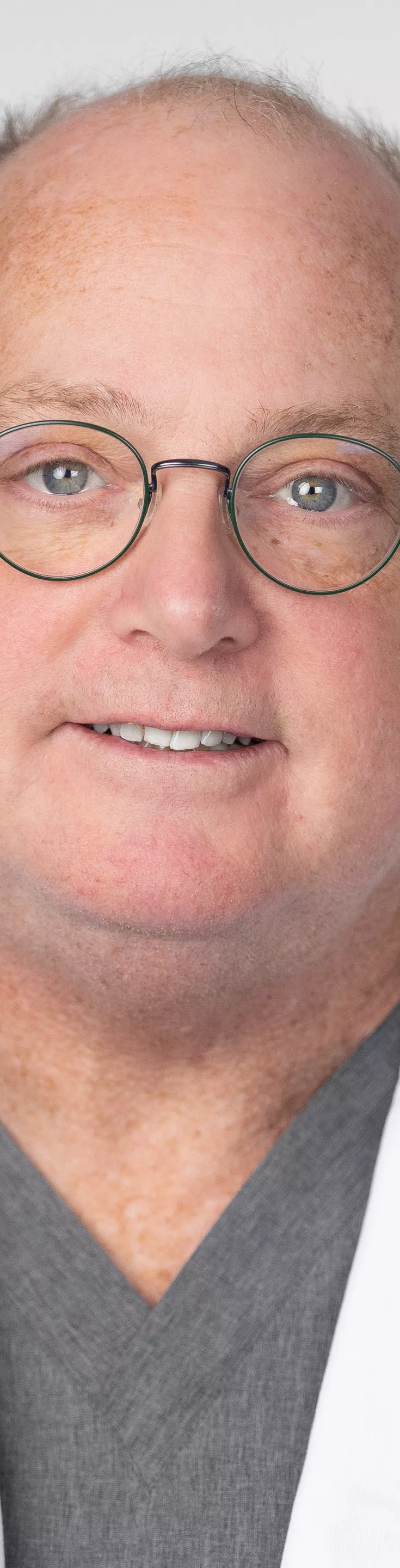 Headshot of Robert Feldman. He is wearing gray scrubs and a white coat.