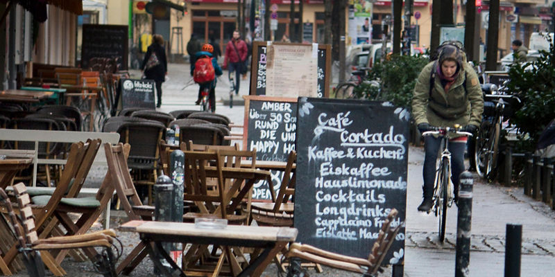 Outdoor café with chalkboard menu on rainy street