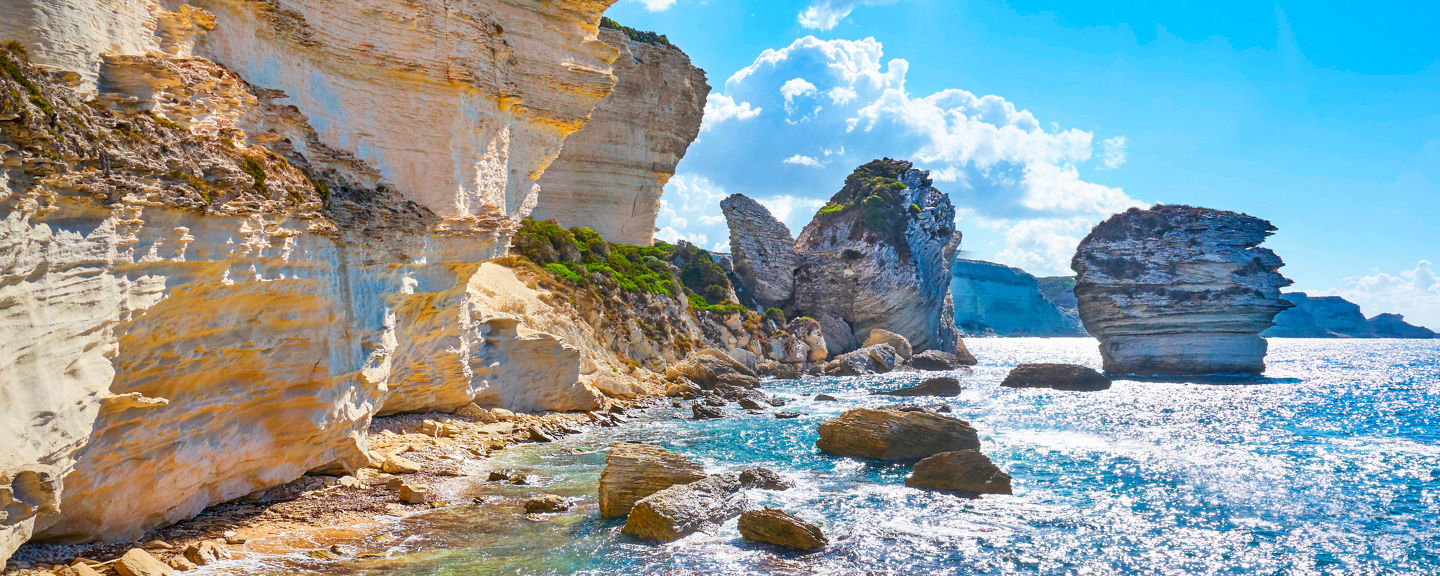 Sunlit coastal cliffs with clear waters