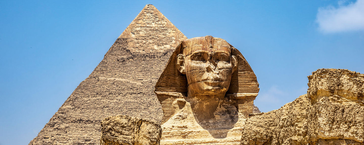 Great Sphinx and Pyramid under blue sky