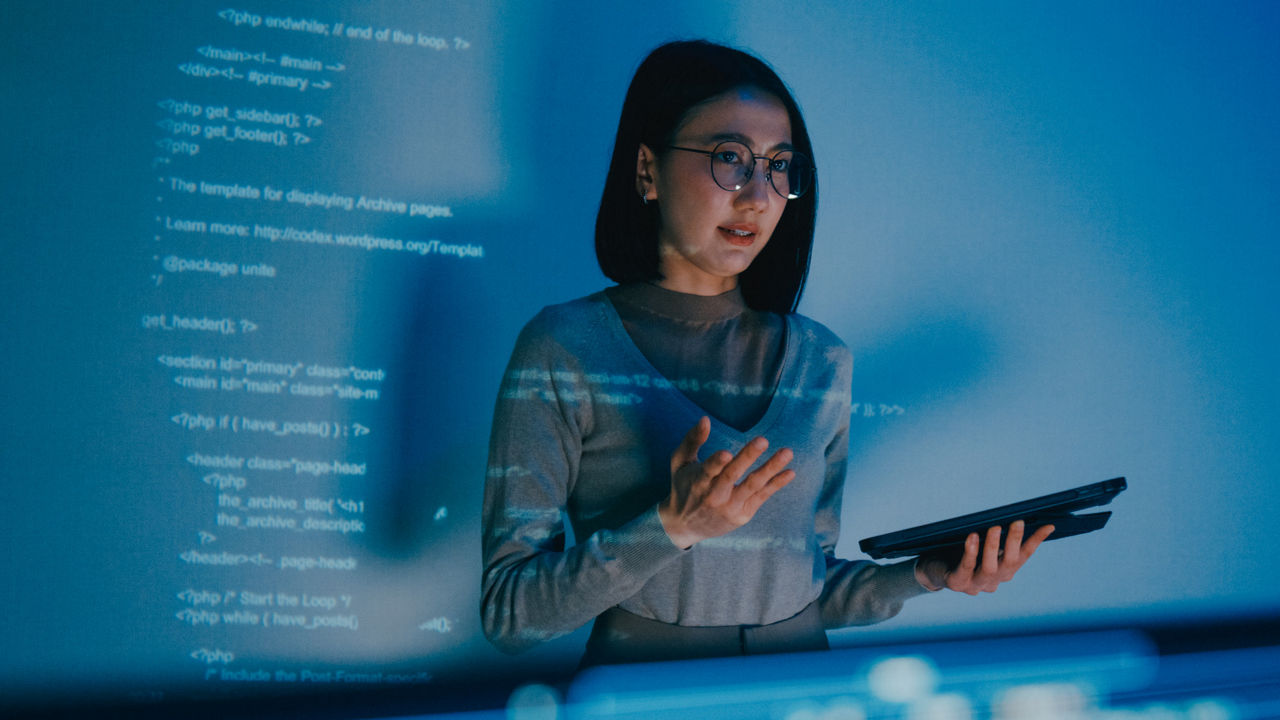  female professional delivering a talk in front of screen